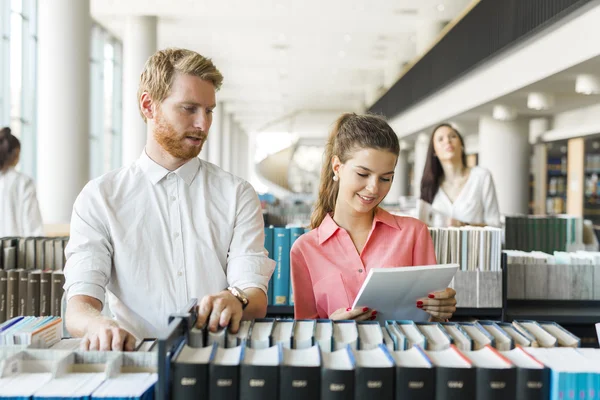 Twee studenten lezen en studeren in bibliotheek — Stockfoto