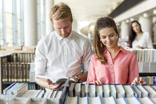 Twee studenten lezen en studeren in bibliotheek — Stockfoto