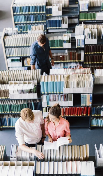 Студенти навчаються, читають у бібліотеці — стокове фото