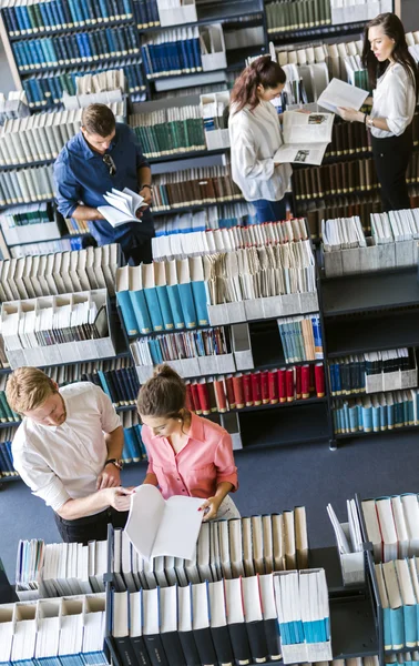 Estudantes aprendendo, lendo na biblioteca — Fotografia de Stock