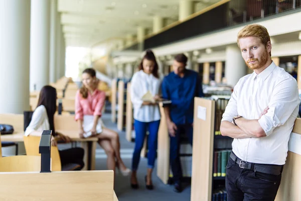 Grupo de pessoas educando-se em uma biblioteca — Fotografia de Stock