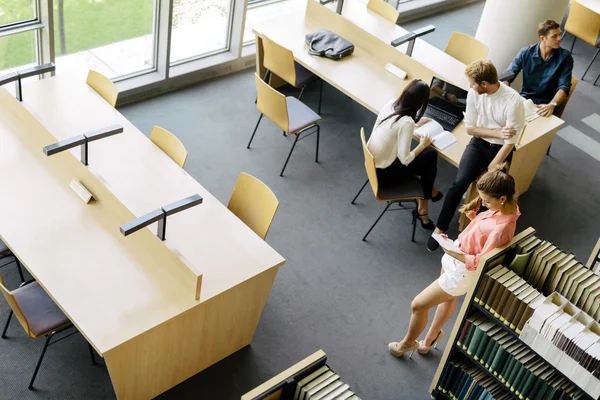 Grupo de estudiantes que estudian en una biblioteca — Foto de Stock