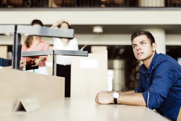 Estudante bonito sentado em uma mesa — Fotografia de Stock