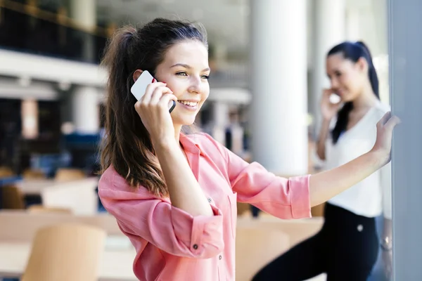 Mujeres que usan teléfonos y hablan durante el descanso —  Fotos de Stock