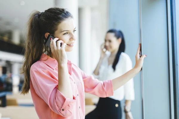 Women using phones and talkin during break — Stock Photo, Image