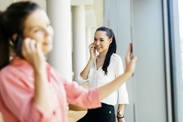 Mulheres usando telefones e conversando durante o intervalo — Fotografia de Stock