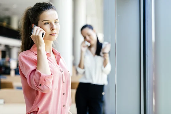 Mujeres que usan teléfonos y hablan durante el descanso — Foto de Stock
