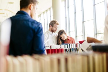 bir grup öğrenci kütüphanede okuyor.