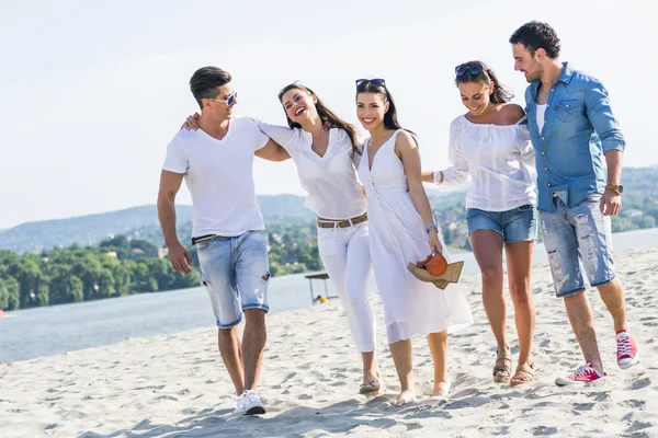 Grupp av människor höll händerna på stranden — Stockfoto