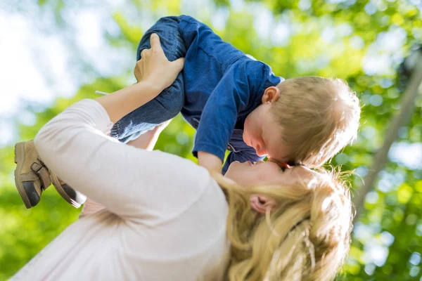 Gülüyor ve çocuğuyla birlikte oynarken gülümseyen anne