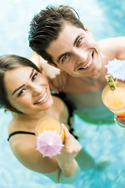 Coppia che beve un cocktail in piscina — Foto Stock