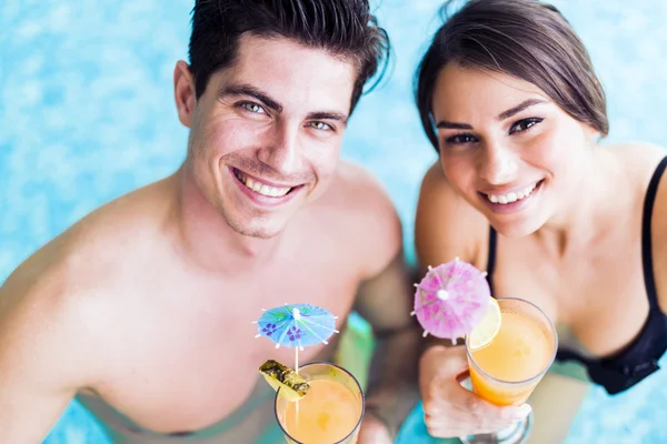 Coppia che beve un cocktail in piscina — Foto Stock