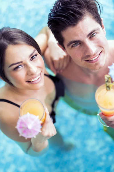 Coppia che beve un cocktail in piscina — Foto Stock