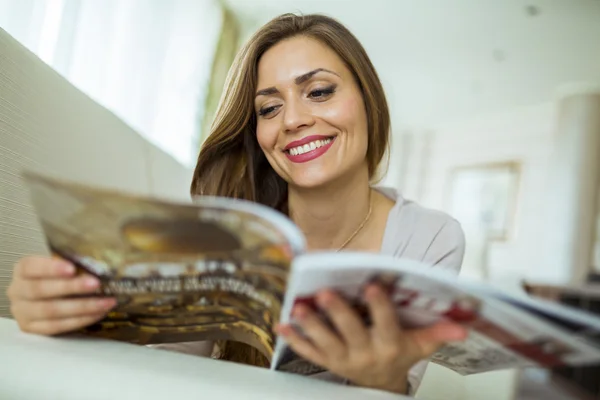Жінка читає газету у вітальні — стокове фото