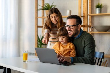 Evde çalışan birden fazla bekar baba. Babalar işi ve aileyi dengeleyebilir aile dizüstü bilgisayarla çalışır ve evde birlikte eğlenir..