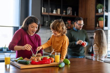Mutlu bir aile mutfakta eğleniyor, hafta sonları birlikte güzel vakit geçiriyorlar. Aile, mutluluk konsepti