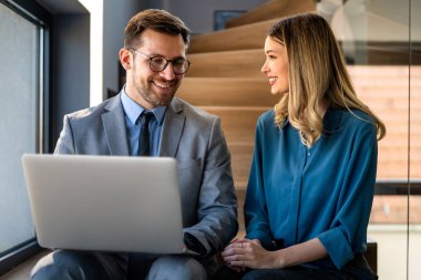 Ofisteki dijital cihazları kullanarak gülümseyen bir yönetici ekibi. Çeşitli profesyonel liderler yöneticiler ve çalışanlar takım çalışmasında çalışan dijital finans projesini tartışıyor.