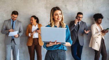 Modern ofisteki çok kültürlü iş adamları dijital teknoloji, bulut çözümleri ve takım çalışmasını kullanarak birlikte şirket başarısı elde ediyorlar.