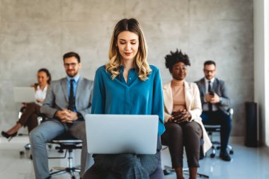 Tam konsantrasyon. Takım olarak çalışan ve kurumsal ofiste iletişim kuran bir grup genç iş adamı.