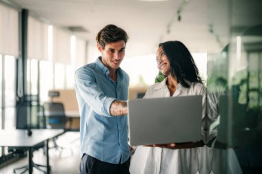İş projesi ekibi şirket ofisindeki toplantı odasında birlikte çalışıyor.