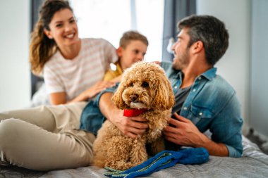 Mutlu bir aile oyunu, evde köpekle eğlenmek. Portre anne, baba ve çocuk oturma odasında kaliteli zaman, sevgi ve bakım için birlikte hafta sonu