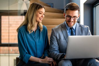 Ofisteki dijital cihazları kullanarak gülümseyen bir yönetici ekibi. Çeşitli profesyonel liderler yöneticiler ve çalışanlar takım çalışmasında çalışan dijital finans projesini tartışıyor.