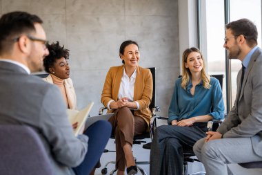 Çeşitli iş adamları ofiste toplanarak beyin fırtınası yaparken yeni proje için yeni fikirleri tartıştılar. Çok ırklı iş arkadaşları toplantı odasında toplandı.