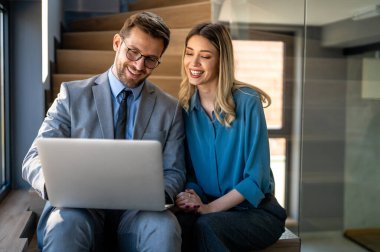 Mixed team of software engineers brainstorming ideas for new code library in front of computer screens compiling algorithms. Diverse app developers collaborating on group project in it agency office.