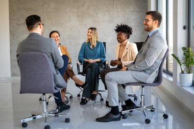 Çeşitli iş adamları grup terapisi seansında daire çiziyor. İş koçu eğitim personeli, eğleniyor, iş yerinde takım oluşturma aktivitesi