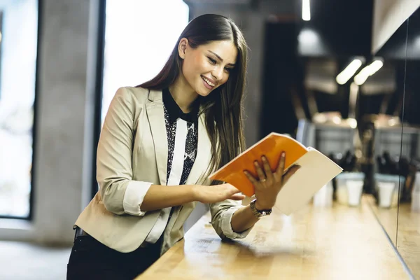 Mujer leyendo el menú en un mostrador —  Fotos de Stock