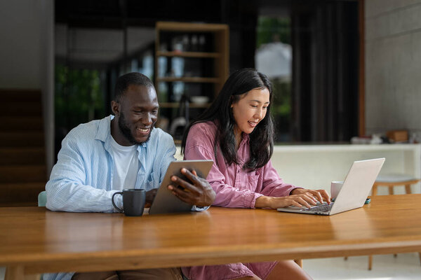 Мультикультурная пара работает удаленно, планируя финансы и инвестиции в Интернете. Цифровой кочевой образ жизни, командная работа и умные финансовые решения откуда угодно