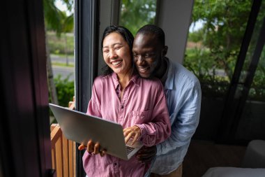 Başarılı çeşitlilik, çok ırklı bağımsız çift, birlikte dizüstü bilgisayarda çalışarak, tropik iklimin huzurlu ortamının tadını çıkarıyor..
