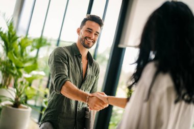 Ofis toplantısındaki mutlu genç iş kadını ve iş adamı tokalaşması. Kadın HR banka müdürü, mali danışman tokalaşan acemi, müşteriyi selamlayan. İş görüşmesinde işe almak, ortaklık kavramı
