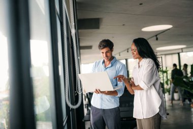 Ofisteki dijital cihazları kullanarak gülümseyen bir yönetici ekibi. Çeşitli profesyonel liderler yöneticiler ve çalışanlar takım çalışmasında çalışan dijital finans projesini tartışıyor.