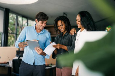 Çeşitli, yetenekli bir takım, bir iş toplantısı sırasında parlak bir ofis alanında etkili bir şekilde işbirliği yapar. Birlikte çalışan başarılı iş arkadaşlarından oluşan yaratıcı bir grup