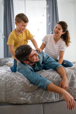 Üç kişilik bir aile evde neşeyle vakit geçirir. Çocukların iyi ruh hali ailelere zevk verir..