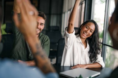 Coşkulu, çeşitli, etnik çeşitlilikte genç meslektaşlar ortak kurumsal başarıyı ya da hedef başarısını kutluyor, modern ofiste kaygısız parti zamanlarının tadını çıkarıyor.