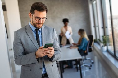 İş projesi ekibi şirket ofisindeki toplantı odasında birlikte çalışıyor.