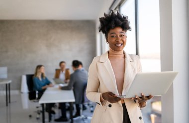 Başarılı mutlu Asyalı iş kadını, yeni başlayan iş arkadaşı ya da yazılım mühendisi modern bir çalışma alanında çalışıyor.