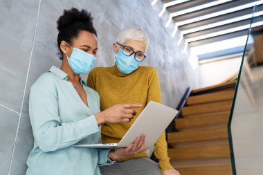 Meşgul iş adamları, programcılar yazılım geliştirici mühendisi ofiste bilgisayar üzerinde çalışıyor. Kadın çoklu etnik programcı koruyucu yüz maskeleri konusunda uzman.