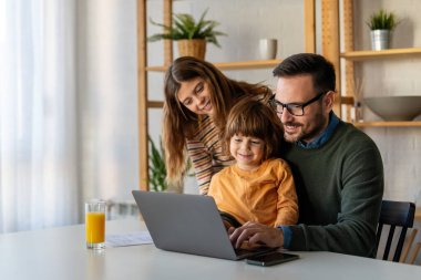 Happy single father with kids having fun online with application, watching video cartoons or playing game on laptop together