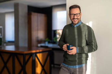 Mutlu, dengeli bir adamın portresi gülüyor, hayattaki küçük şeylerden zevk alıyor. Neşeli yakışıklı erkek sabah kahvesi içiyor. Mutluluk insanlar başarı kavramı