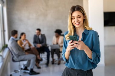 Ofisteki dijital cihazları kullanarak gülümseyen bir yönetici ekibi. Çeşitli profesyonel liderler yöneticiler ve çalışanlar takım çalışmasında çalışan dijital finans projesini tartışıyor.