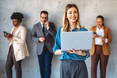 Tam konsantrasyon. Takım olarak çalışan ve kurumsal ofiste iletişim kuran bir grup genç iş adamı.