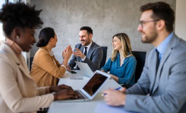Çeşitli iş adamları ofiste toplanarak beyin fırtınası yaparken yeni proje için yeni fikirleri tartıştılar. Çok ırklı iş arkadaşları toplantı odasında toplandı.