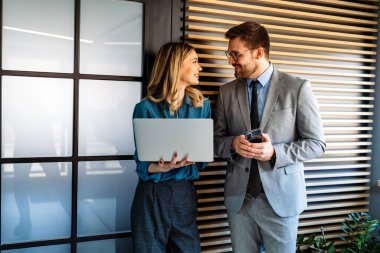 Tam konsantrasyon. Takım olarak çalışan ve kurumsal ofiste iletişim kuran bir grup genç iş adamı.