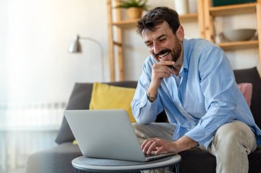 Ofiste dizüstü bilgisayarla çalışan gülümseyen bir iş adamı. Bilgisayarda uzaktan eğitim, sanal eğitim kullanan genç öğrenci ya da uzaktan öğretmen.