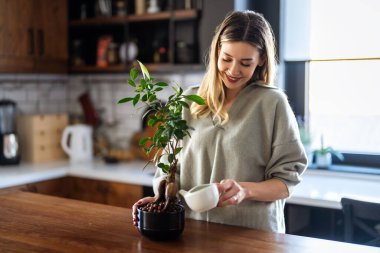 Evde ekolojik farkındalık yaratan bir kadın, bitkilerini sürdürülebilir ve düşünceli bir yaşam tarzına katkıda bulunmak için yetiştiriyor.