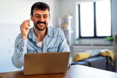 Ofiste dizüstü bilgisayarla çalışan gülümseyen bir iş adamı. Bilgisayarda uzaktan eğitim, sanal eğitim kullanan genç öğrenci ya da uzaktan öğretmen.