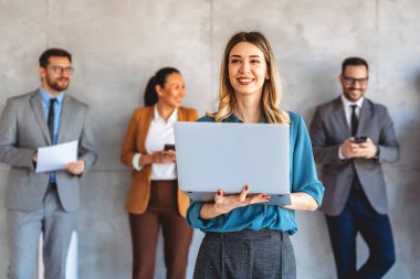 Ofisteki dijital cihazları kullanarak gülümseyen bir yönetici ekibi. Çeşitli profesyonel liderler yöneticiler ve çalışanlar takım çalışmasında çalışan dijital finans projesini tartışıyor.